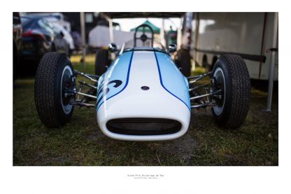 Vue de face d'un véhicule de course de collection bleu ciel et blanc dans son stand avant sa course au Grand Prix de Pau Historique